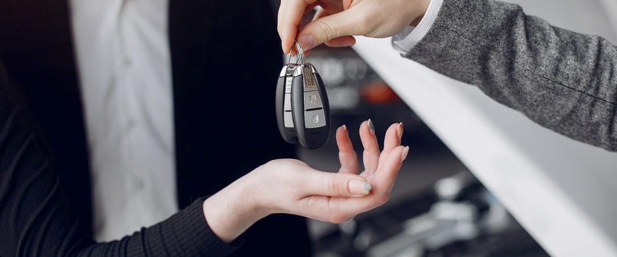 Couple in a car salon. Family buying the car. Elegant woman with her husband. Assistant with a clients