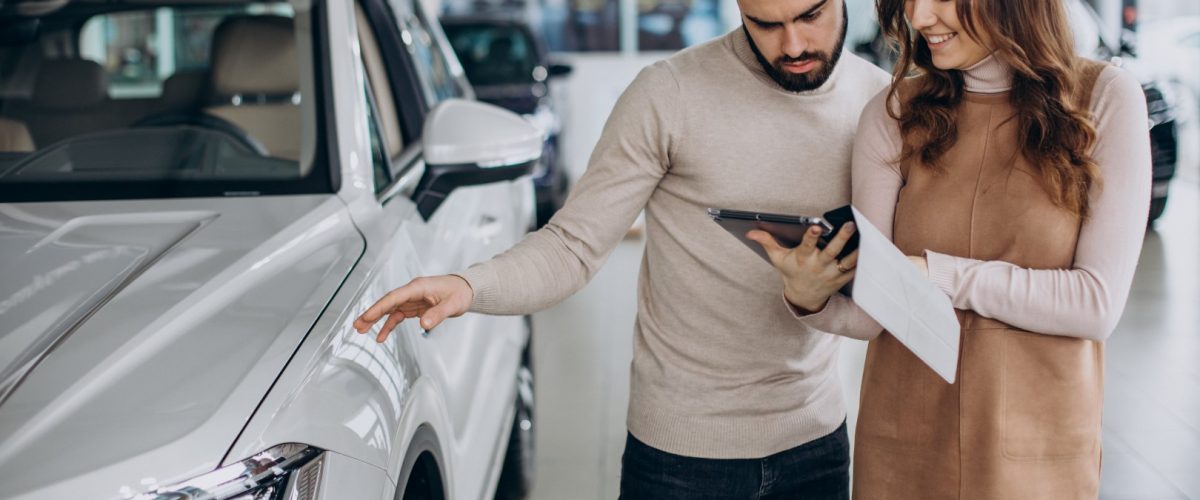 Saleswoman talking to customer in a car salon