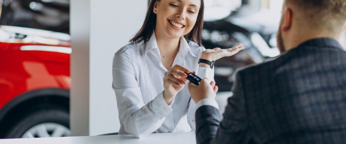 Man with sales woman in car showroom
